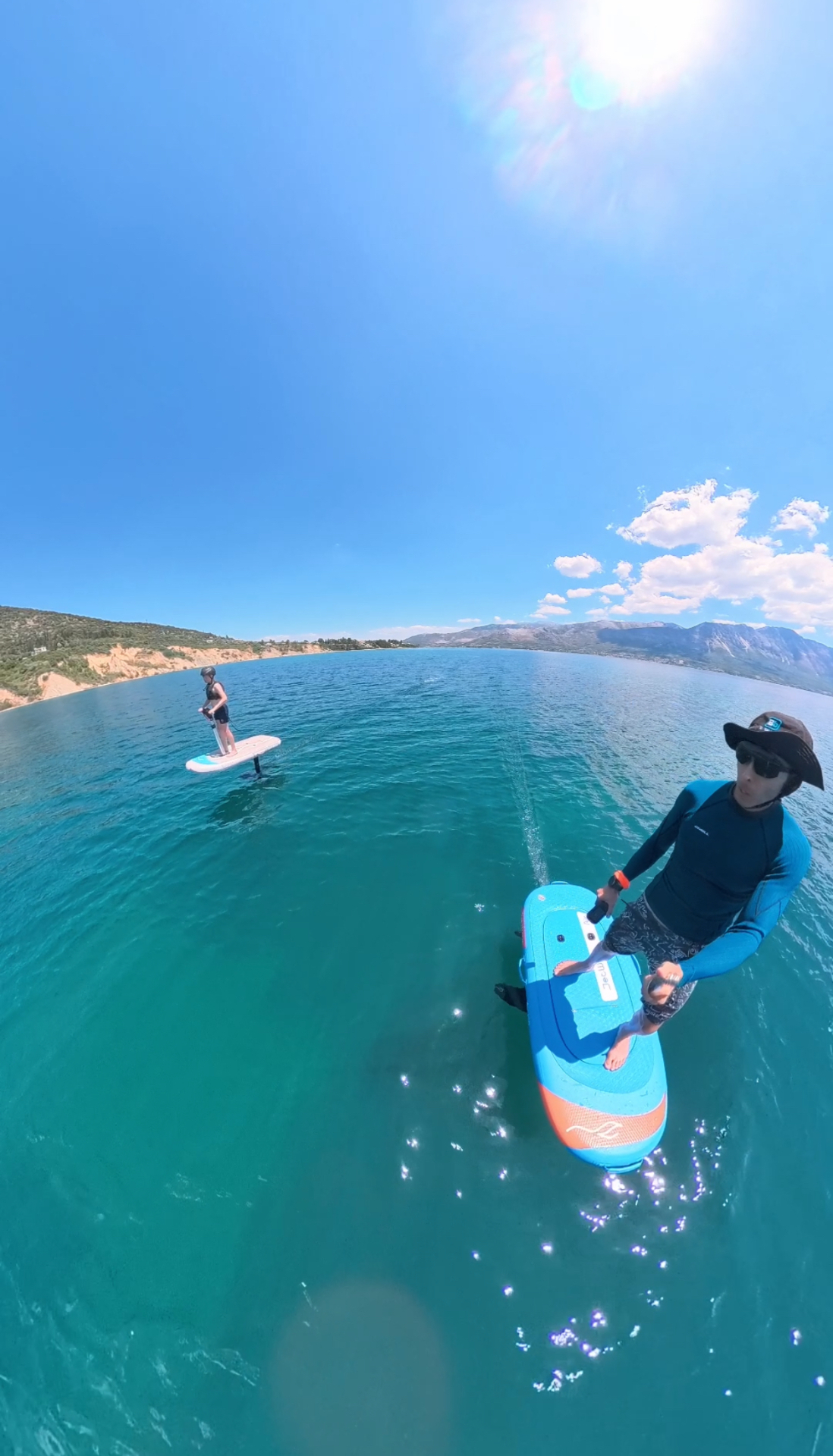 Two riders e-foiling together on calm Ionian waters