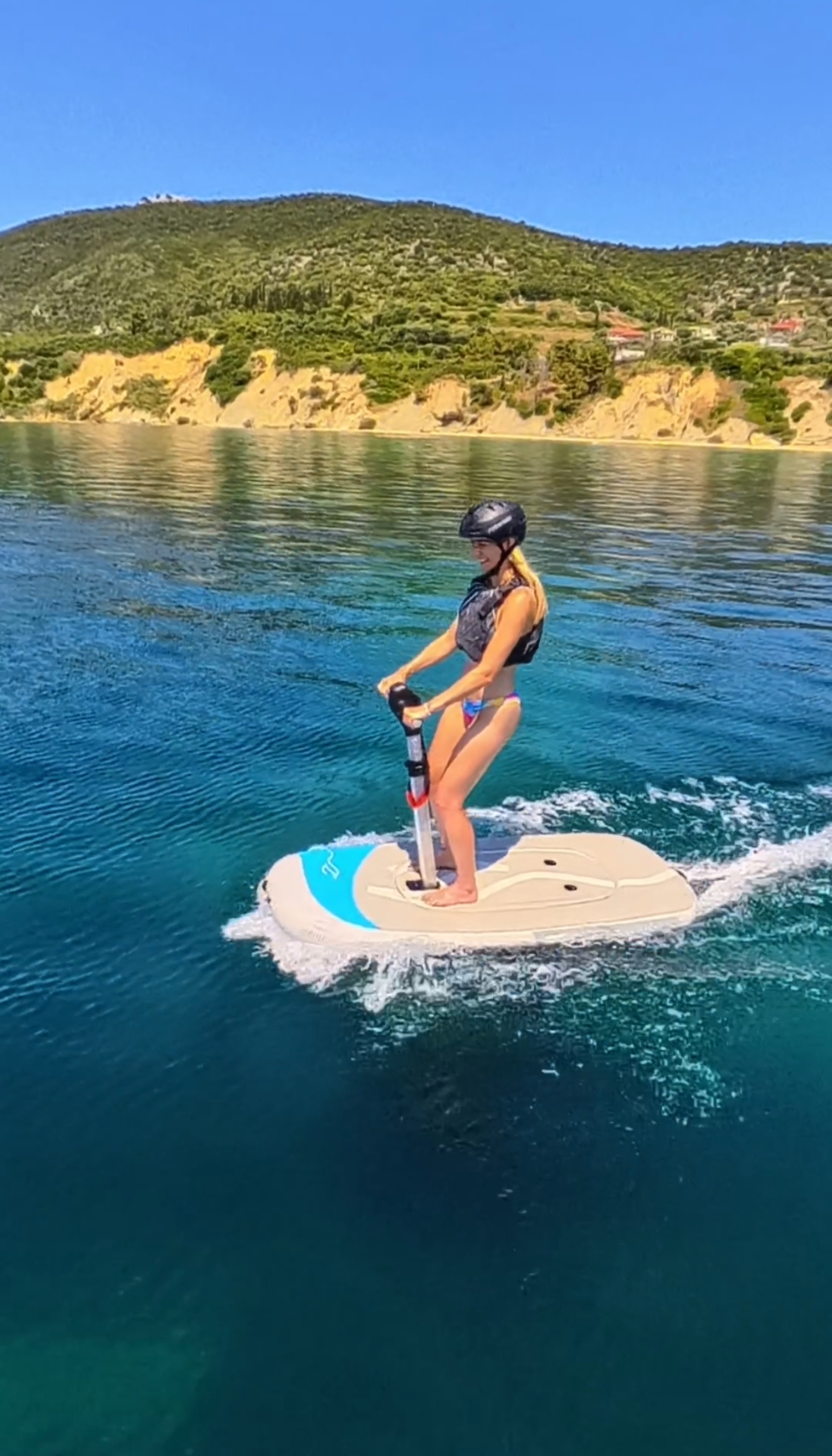 Smiling rider cruising on a jet board along the coast