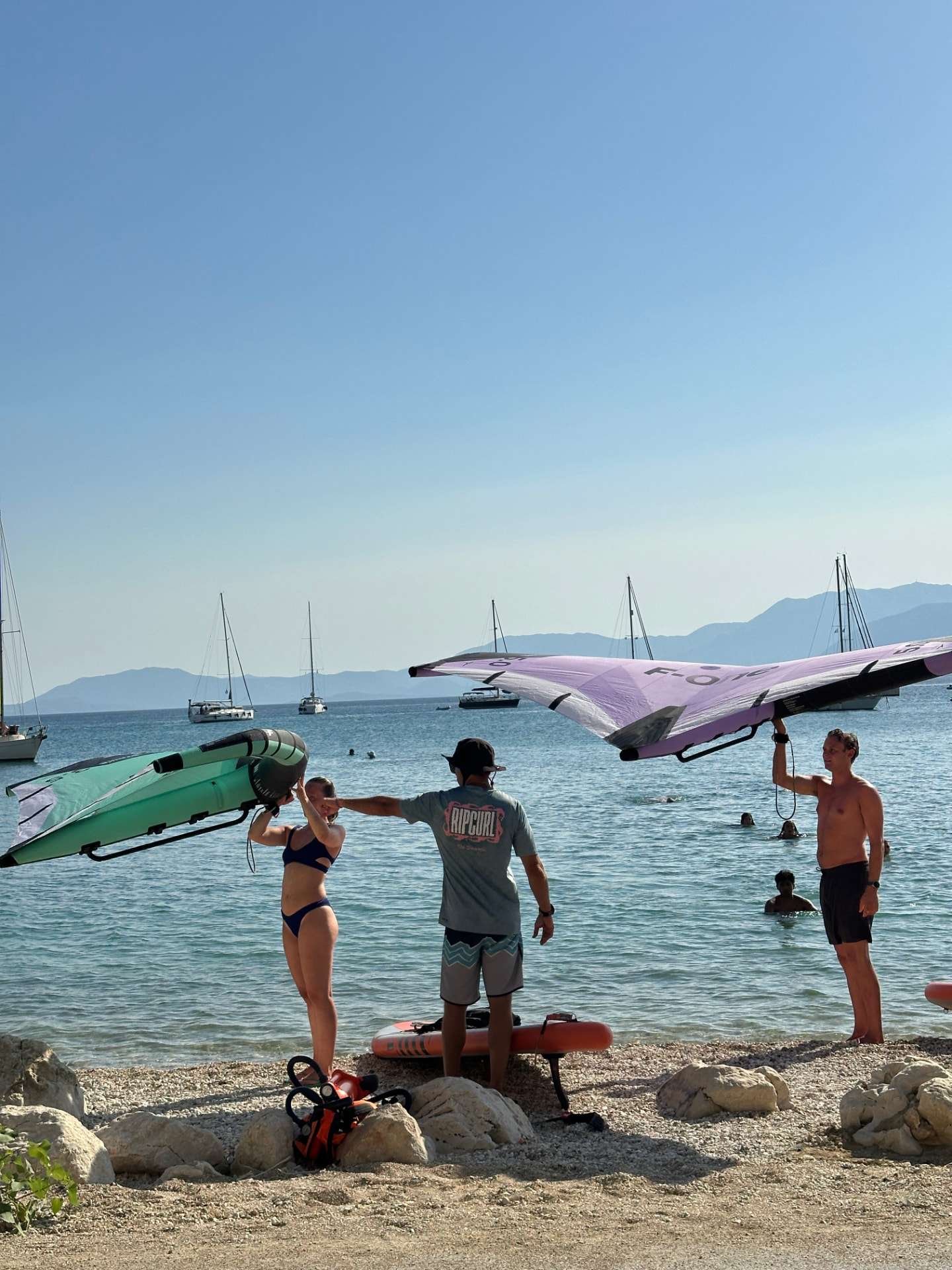 Instructor briefing wing surf students holding wings on the beach in Paleros