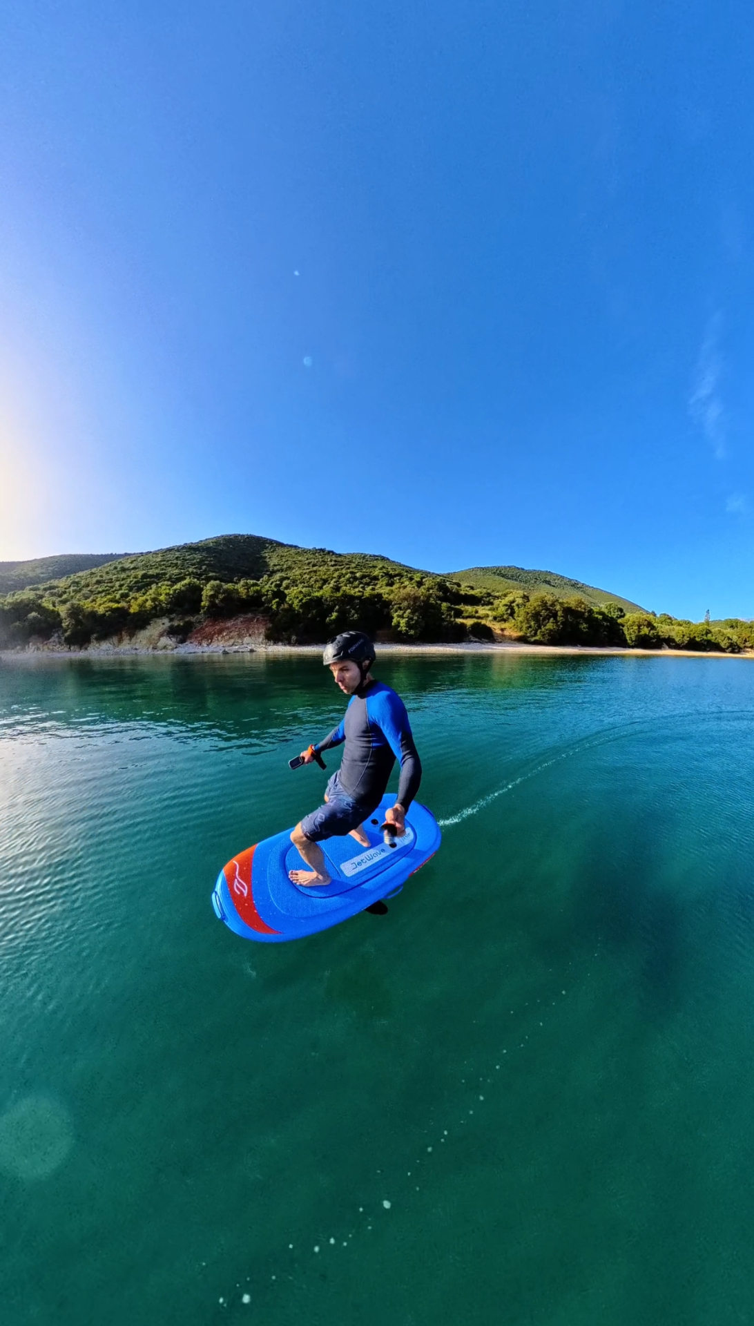 E-foil rider gliding above emerald water in Greece