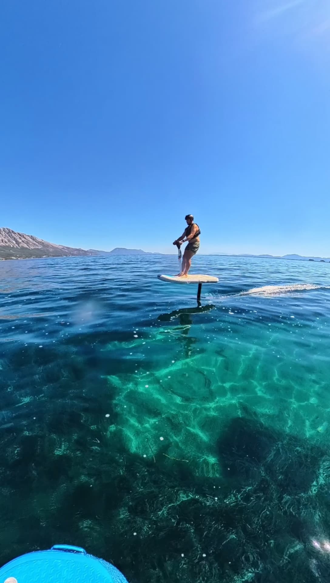 E-foiler cruising over deep blue Ionian water with mountains behind
