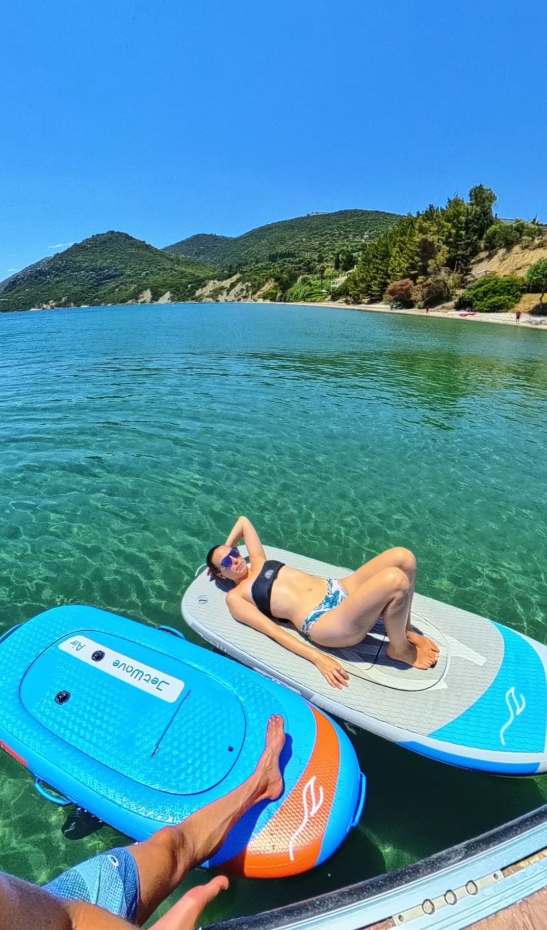 Relaxing on a paddleboard in a turquoise Greek bay