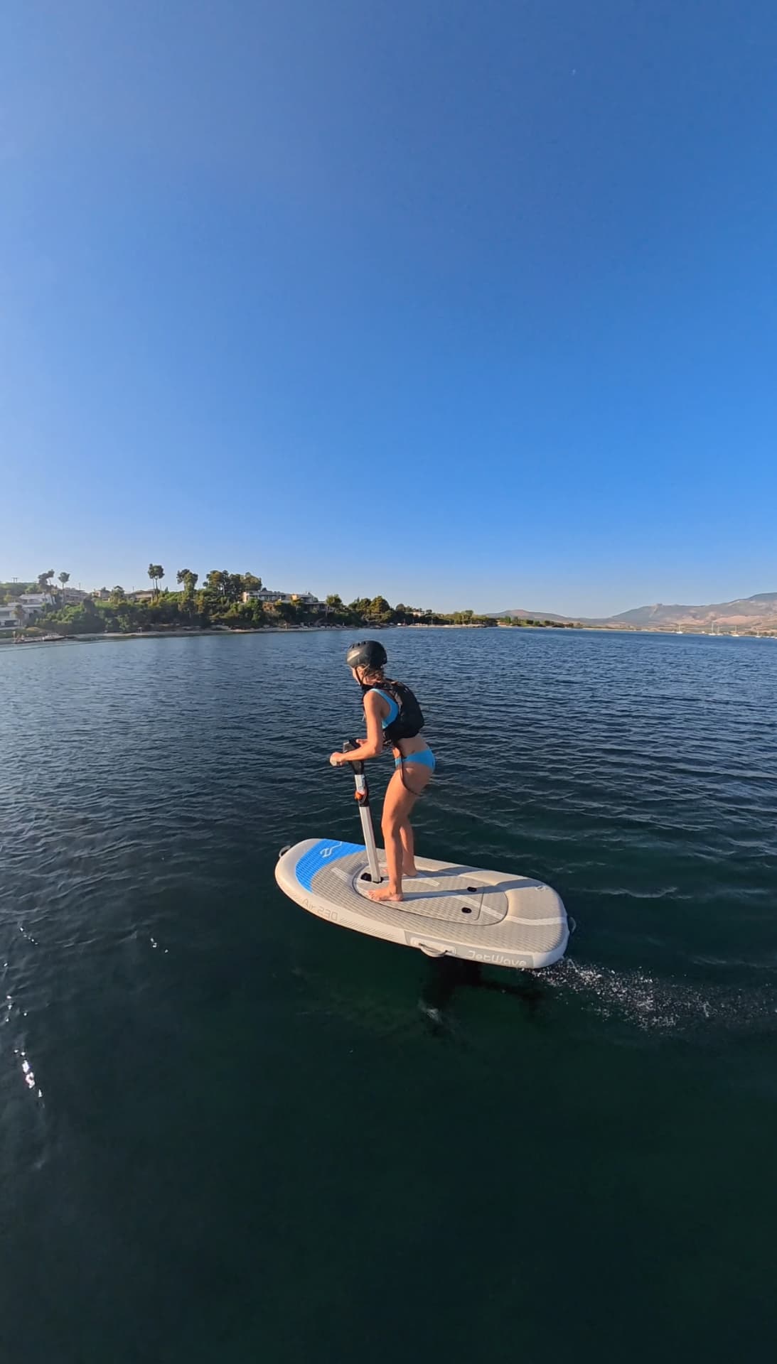 Rider on an e-foil board in the evening light near the Paleros coast