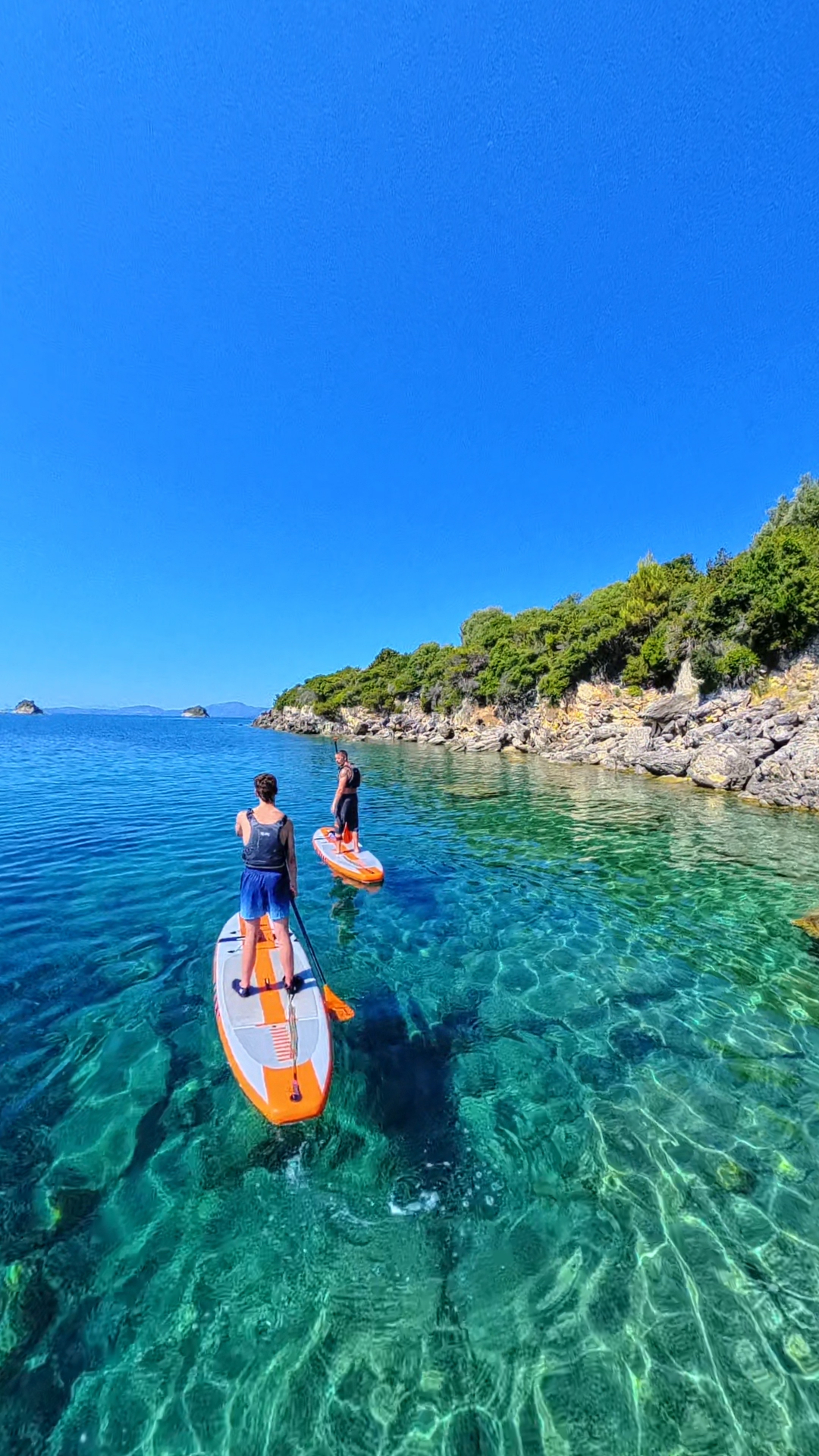Two paddleboarders exploring the rocky Ionian coastline